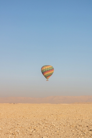 Another balloon coming in for a landing on the flat desert sand